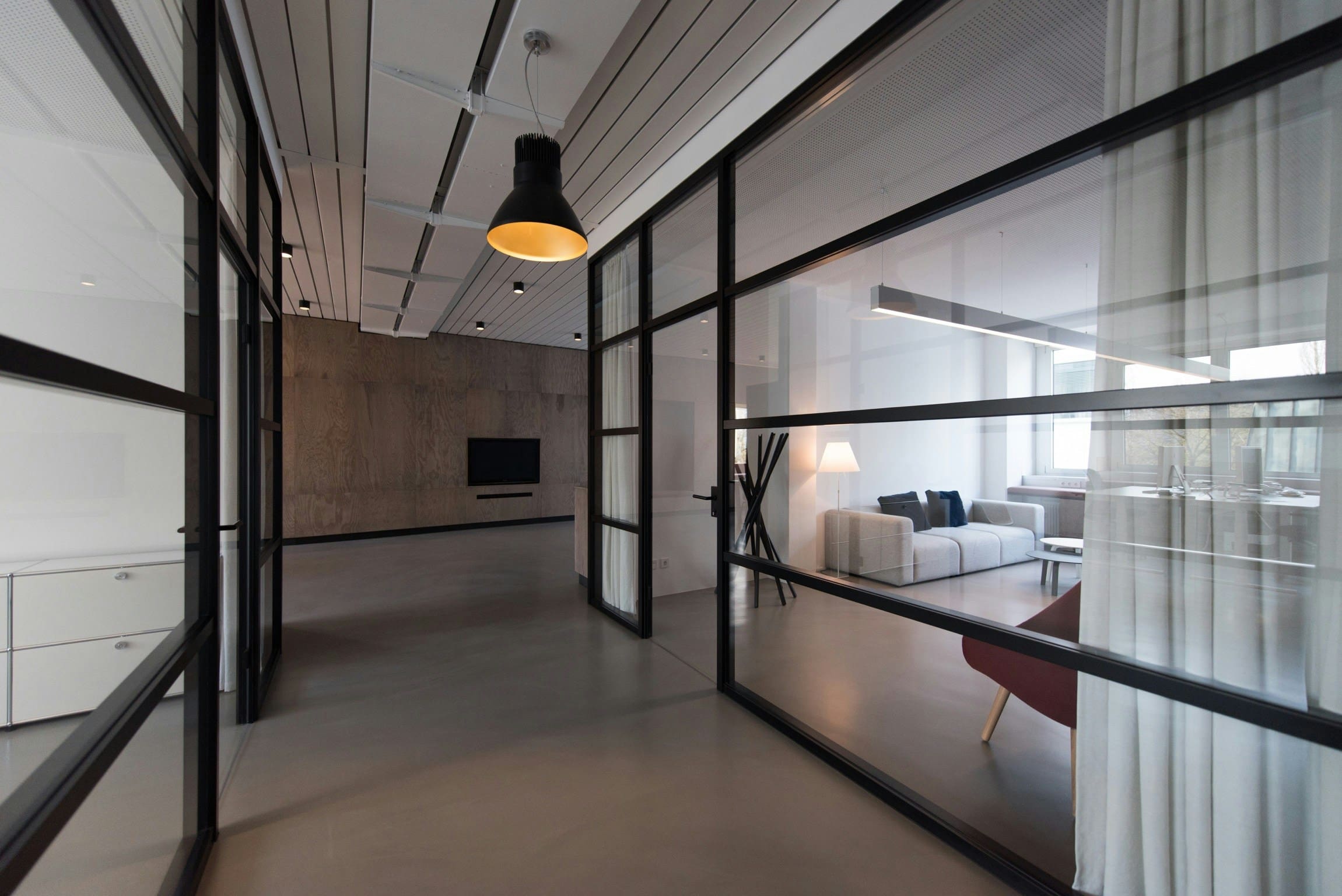 A room with glass walls and a black door.