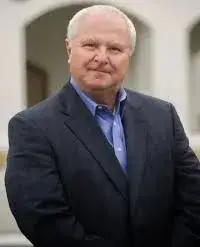 A man in a suit and tie standing outside.